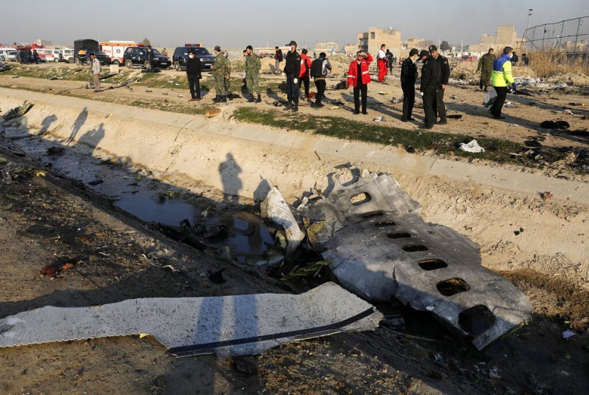 Warga berkerumun di antara puing pesawat Ukraina yang jatuh di Shahedshahr, barat daya ibu kota Teheran, Iran, Rabu (8/1). Pesawat itu membawa 176 penumpang yang jatuh tak lama setelah lepas landas.