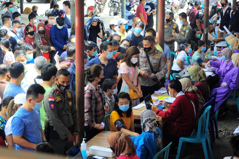 Warga berkerumun saat antre vaksinasi COVID-19 massal dosis pertama di Terminal Rawasari, Jambi, Senin (19/4/2021). Vaksinasi yang sedianya menargetkan petugas pelayanan publik sektor transportasi tersebut justru dipadati masyarakat umum sehingga mengakibatkan kerumunan. 