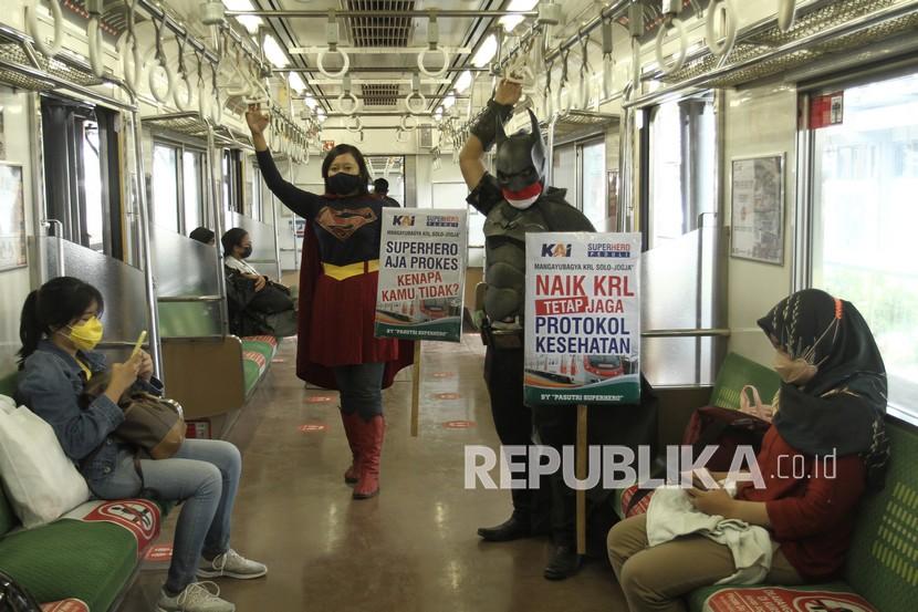 Warga berkostum superhero membawa poster ajakan mematuhi protokol kesehatan saat menaiki Kereta Rel Listrik (KRL), (ilustrasi).