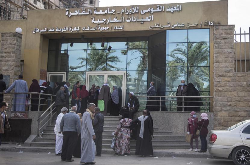  Warga berkumpul di depan National Cancer Institute, Kairo, setelah Mesir mengumumkan ada 15 kasus positif Covid-19 di rumah sakit tersebut yang melibatkan tiga dokter dan 12 perawat pada  4 April 2020. 