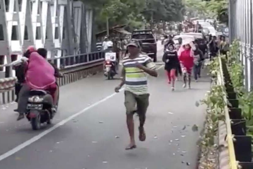 Warga berlarian karena panik akibat jembatan Beli di Lombok Utara retak akibat gempa bumi kembali mengguncang Lombok