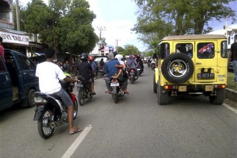 Warga berlarian ke dataran yang lebih tinggi usai gempa yang terjadi di Banda Aceh, Rabu (11/4). 