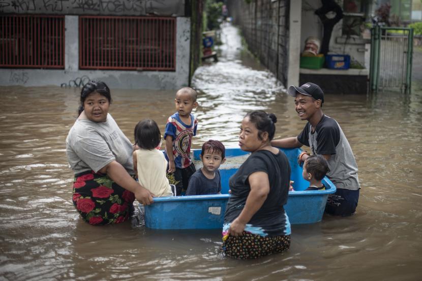 Warga bermain bersama keluarganya saat banjir di Jalan Kapten Tendean, Mampang Prapatan, Jakarta, Sabtu (20/2/2021). Banjir tersebut disebabkan karena curah hujan tinggi sejak Jumat (19/2) malam. 