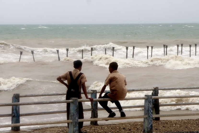  Warga bermain di pingiran pantai Tedis saat cuaca ekstrim melanda Kota Kupang, NTT