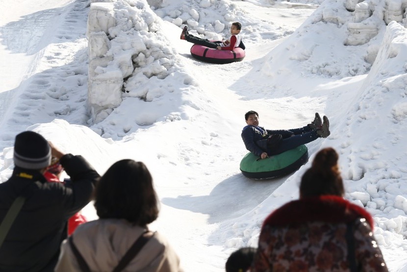 Warga bermain salju di salah satu taman di Beijing, Cina.