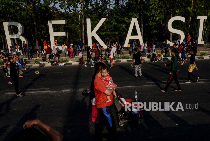 Warga berolahraga di area hari bebas kendaraan bermotor (HBKB) di Kota Bekasi, Jawa Barat. 