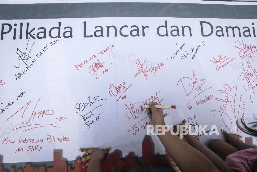 Warga berpartisipasi dalam bentuk tanda tangan sebagai bentuk dukungan terhadap Pilkada Damai saat Hari Bebas Kendaraan Bermotor (HBKB) di Jalan M.H Thamrin, Jakarta, Ahad (16/4). 
