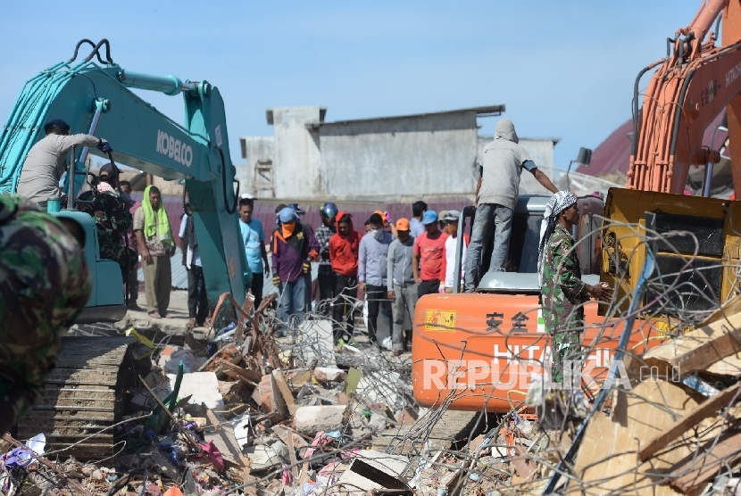  Warga bersama aparat melakukan evakuasi lanjutan di reruntuhan ruko di Pasar Meureudu, Pidie Jaya, NAD, Kamis (8/12).