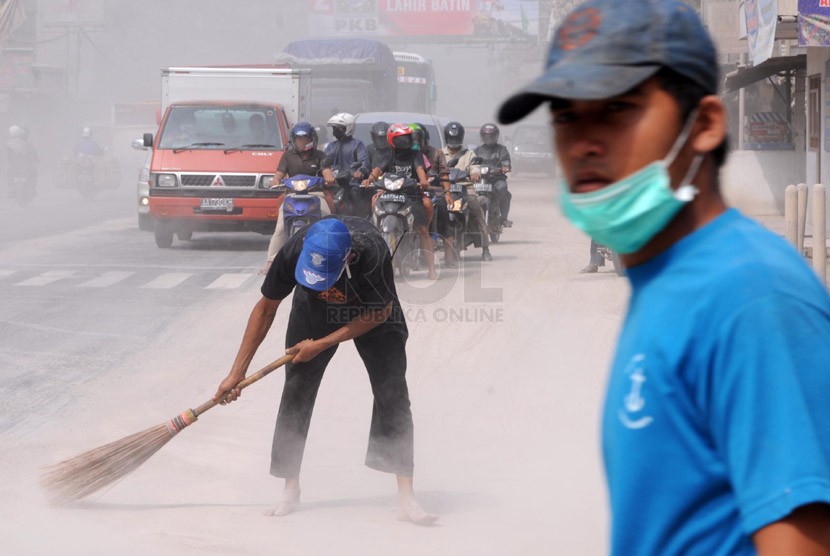  Warga bersama petugas TNI dan Kepolisian membersihkan abu vulkanik yang menyelimuti Jalan MT Haryono, Kutoarjo, Purworejo, Jawa Tengah, Sabtu (15/2). (Republika/Adhi Wicaksono)