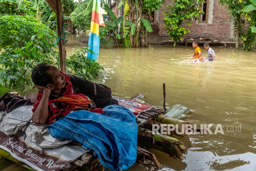  Pengungsi Banjir Demak Mulai Mendapatkan Trauma Healing. Foto: Warga bertahan di depan rumahnya yang terendam banjir akibat Sungai Tuntang jebol di Desa Trimulyo, Guntur, Kabupaten Demak, Jawa Tengah, Jumat (10/1/2020). 
