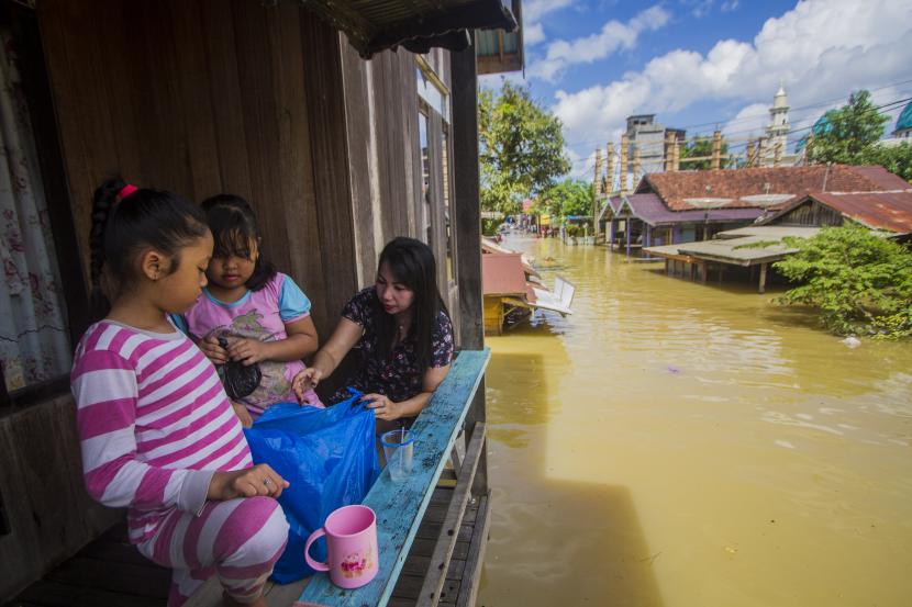 Warga bertahan di rumahnya saat banjir merendam permukiman di Kalimantan