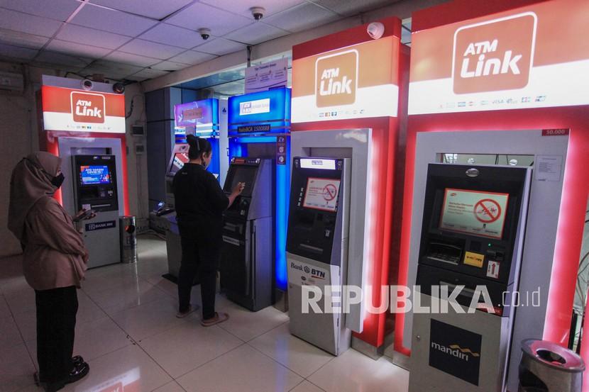 Warga bertansaksi melalui mesin anjungan tunai mandiri (ATM) di Galeri ATM Stasiun KA Juanda, Jakarta, Ahad (6/3/2022).