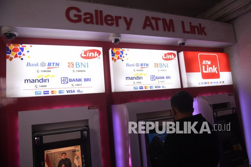 Warga bertransaksi melalui anjungan tunai mandiri (ATM) di Jakarta, Selasa (21/12/2021). Bank Indonesia secara resmi meluncurkan BI-Fast Payment yang membuat skema harga transfer antar bank turun menjadi Rp2.500 