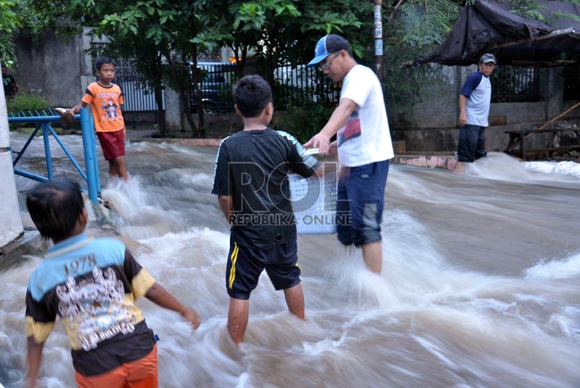   Warga berusaha melintasi derasnya arus akibat jebolnya Tanggul Kali Laya di Perumahan Bukit Cengkeh II cimanggis, Depok, Jawa Barat, Selasa (13/11). (Rakhmawaty La'lang)