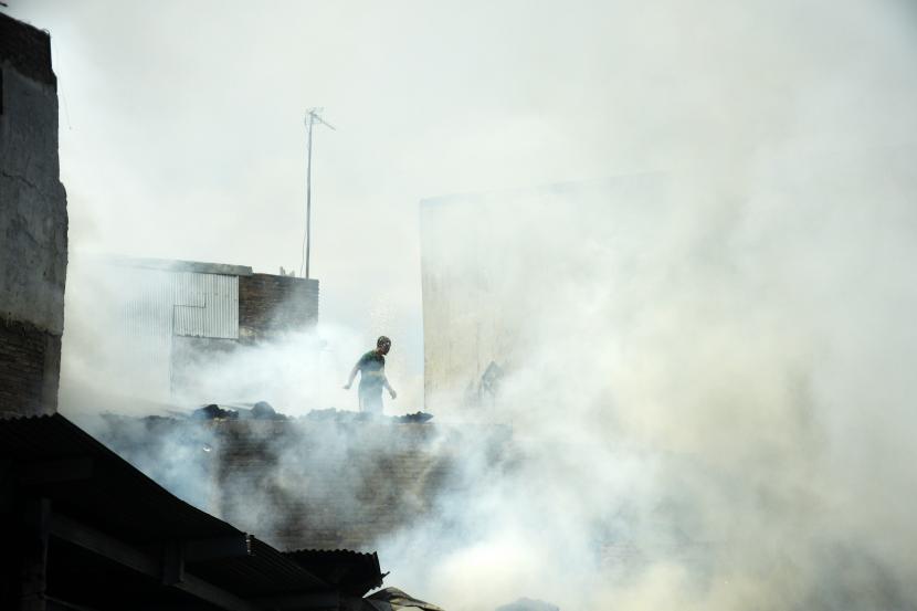 Warga berusaha memadamkan api dengan peralatan seadanya saat terjadi kebakaran permukiman padat penduduk di Kecamatan Rappocini, Makassar, Sulawesi Selatan, Sabtu (31/7/2021). Meski tidak ada korban jiwa pada kebakaran tersebut namun sejumlah rumah hangus terbakar dan kerugian ditaksir ratusan juta rupiah sementara penyebab kebakaran masih dalam penyelidikan.