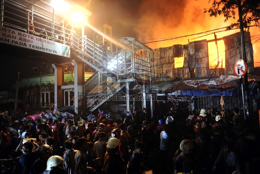  Warga berusaha memadamkan api saat kebakaran melanda kawasan pasar Gembrong dan pemukiman di Prumpung, Jakarta, Selasa (4/8)malam. 