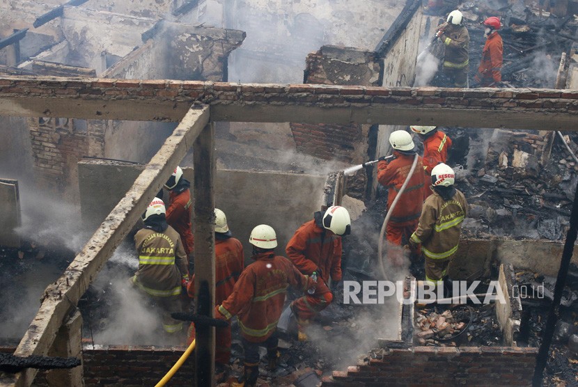 Warga berusaha memadamkan api saat terjadi kebakaran di Johar Baru, Jakarta, Senin (5/8/2019).