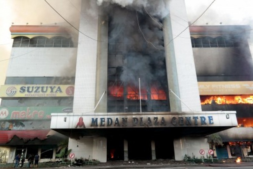 Warga berusaha memadamkan api yang membakar Medan Plaza Centre, Sumatera Utara, Sabtu (22/8). Belum diketahui penyebab terbakarnya salah satu plaza tertua di Medan tersebut. 