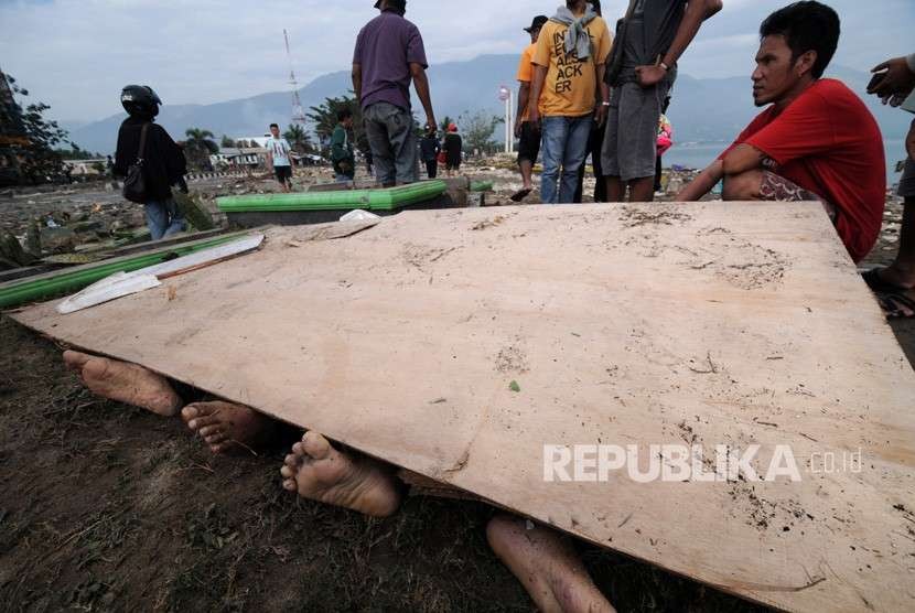 Warga berusaha mengidentifikasi anggota keluarganya di antara jenazah korban gempa dan tsunami di Pantai Talise Palu, Sulawesi Tengah, Sabtu (29/9).