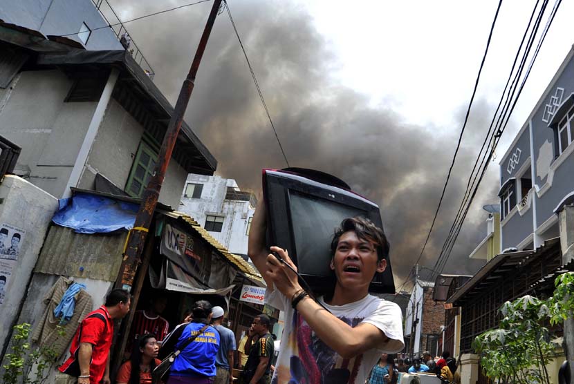  Warga berusaha menyelamatkan barang miliknya saat kebakaran terjadi di Mangga Besar 