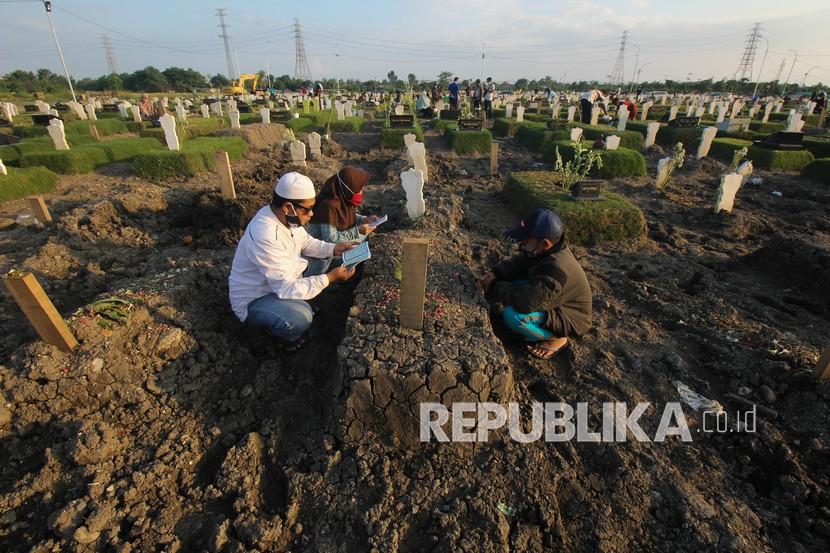 Warga ziarah di makam. Di Surabaya sejumlah pasien isoman yang belum diketahui positif Covid-19 atau tidak dikebumikan di makam kampung tanpa protokol Covid-19.