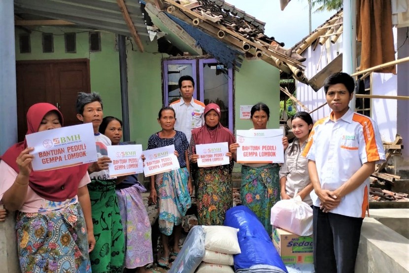 Warga besama relawan BMH foto bersama untuk simbolis penyerahan bantuan di Lombok Timur.