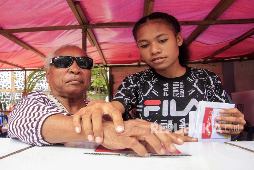 Petugas membantu penyandang disabilitas memasukkan surat suara ketika mengikuti pemilu 2019 susulan di TPS 31 Jayapura Selatan, Jayapura, Papua, Kamis (18/4/2019). 