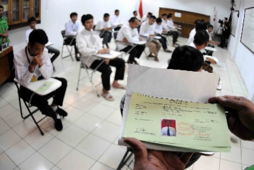 Warga binaan menjalani Ujian Nasional di Lembaga Pemasyarakatan Cipinang, Jakarta Timur, Senin (13/4). 