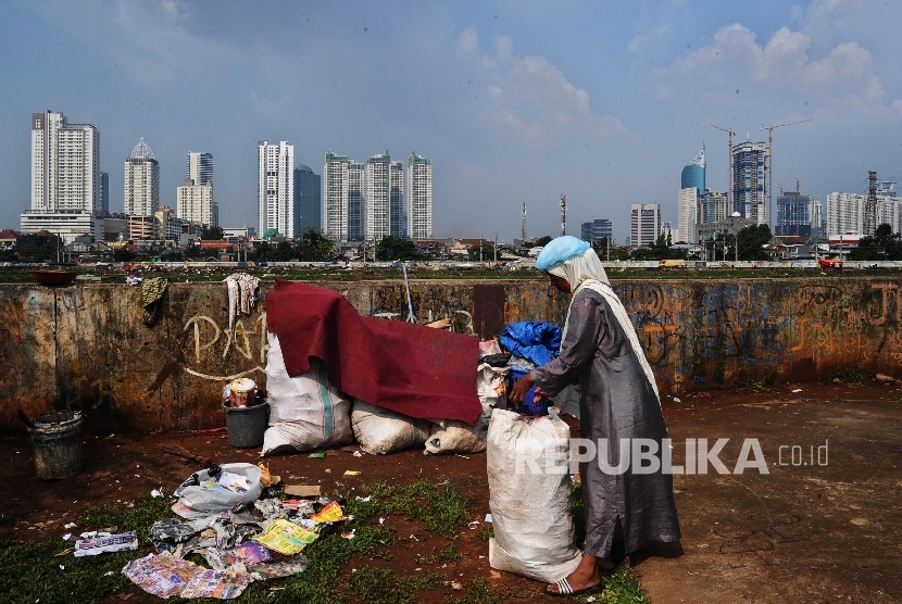 Warga brerjalan saat mengumpulkan sisa produk plastik di Jakarta, Senin (18/7)