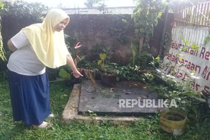Warga Caringin, Bogor, Shinta menunjukkan sumur di rumahnya yang kering dan tak lagi bisa dipakai sejak berdirinya pabrik air mineral di wilayahnya.