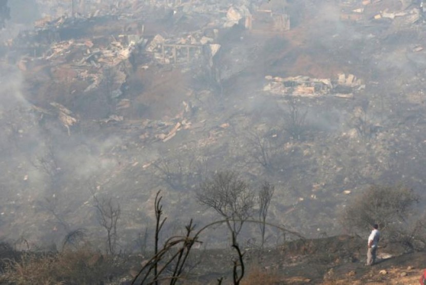 Warga Cile memandangi sekitar 100 rumah yang terbakar di bukit Valparaiso, Cile, Senin (2/1).