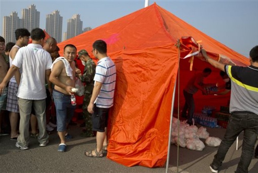 Warga Cina mengantre menerima sarapan karena tidak diizinkan kembali ke rumah mereka dekat lokasi ledakan gudang di Kota Tianjin, Rabu (12/8). 