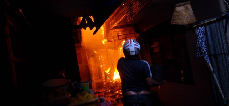 Warga dan petugas pemadam kebakaran berusaha memadamkan api yang membakar permukiman warga di kawasan Jalan Lautze, Jakarta Pusat, Selasa,(7/2). (Republika/Prayogi)