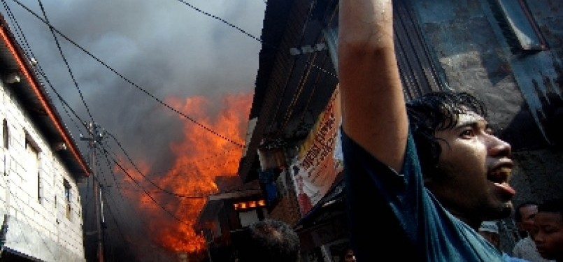 Warga dan petugas pemadam kebakaran berusaha memadamkan api yang membakar permukiman warga di kawasan Jalan Lautze, Jakarta Pusat, Selasa (7/2). 