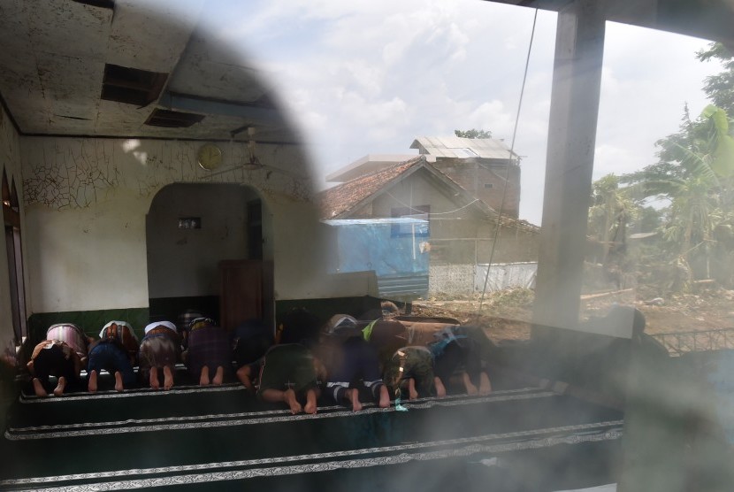 Warga dan relawan melaksanakan Salat Jumat di Masjid Al Mukmin yang berada di lokasi bencana banjir bandang aliran Sungai Cimanuk, Kampung Cimacan, Tarogong, Kabupaten Garut, Jawa Barat, Jumat (23/9).