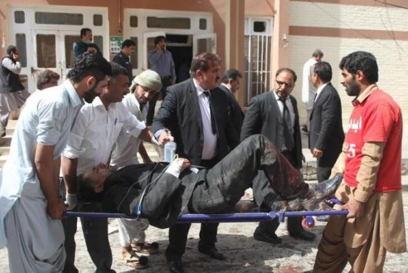 Warga dan relawan menolong seorang pria yang terluka dari lokasi ledakan rumah sakit di Quetta, Pakistan, 8 Agustus 2016.