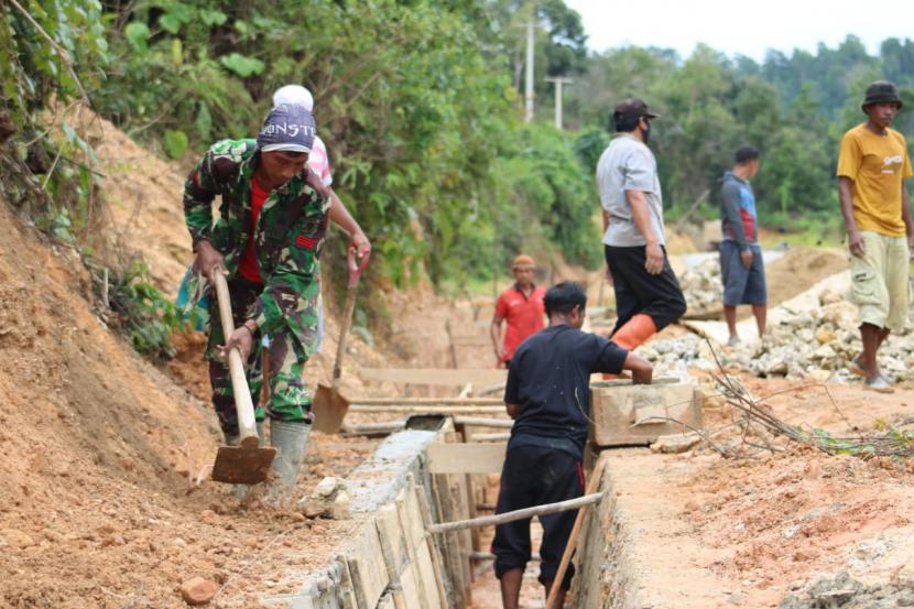 Warga dan Satgas TMMD saling membantu mengerjakan penyelesaian drainase sepanjang 196 meter di Desa Lamoluo, Kecamatan Wawonii Barat, Senin (13/7).