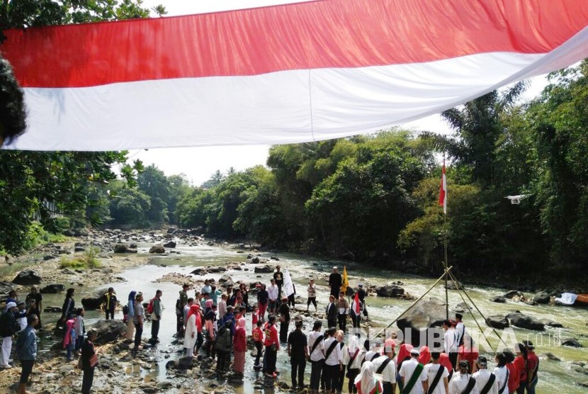 Warga dan sejumlah komunitas di Kota Sukabumi menggelar upacara hari kemerdekaan dan membentangkan bendera merah putih sepanjang 72 meter di pinggir Sungai Cimandiri, Kecamatan Lembursitu, Rabu (17/8).