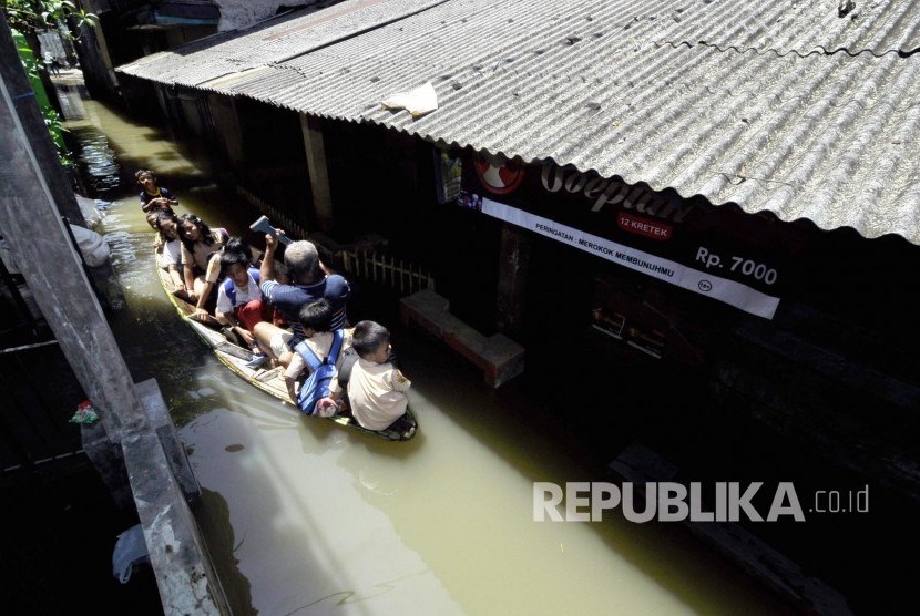 Warga dan siswa SD melintasi genangan air menggunakan perahu di Desa Cigosol, Kecamatan Baleendah, Kabupaten Bandung, Jumat (3/3). 