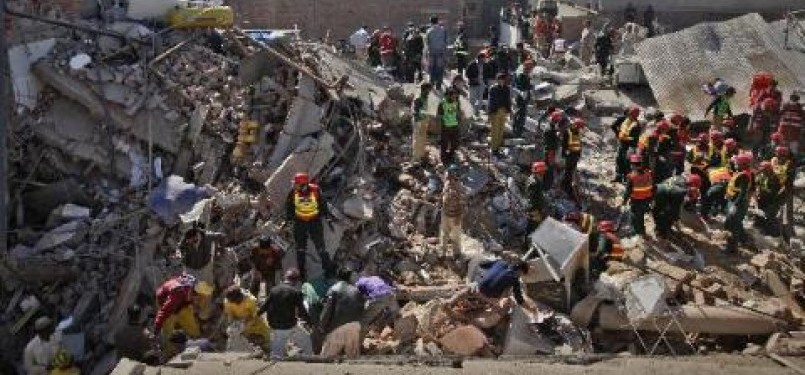 Warga dan tim penyelamat mencari korban di balik reruntuhan bangunan pabrik di Lahore (6/2).
