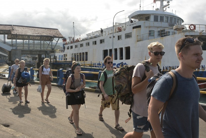 Warga dan wisatawan mancanegara berjalan menuju kapal feri tujuan Pelabuhan Lembar, NTB di Pelabuhan Padangbai, Karangasem, Bali (ilustrasi).