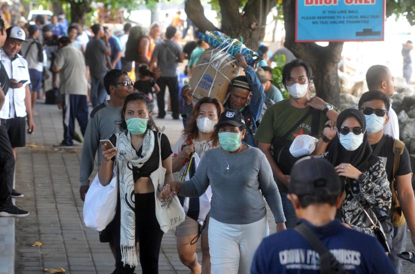 Warga dan wisatawan mengenakan masker di kawasan Pantai Sanur, Denpasar, Bali, Selasa (17/3/2020).