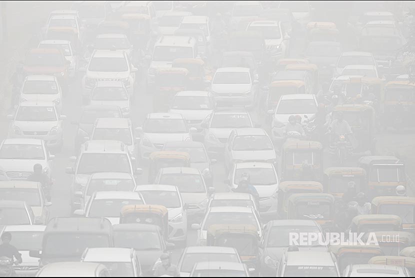 Warga Delhi menyeberangi jalanan di New Delhi yang tersaput kabut asap.