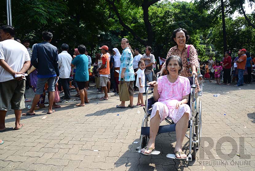 Warga dengan kursi roda bergegas pulang setelahmendapatkan dana Program Simpanan Keluarga Sejahtera (PSKS) di Kantor Pos Pasar Baru, Jakarta Pusat, Rabu(24/12). (Republika/Raisan Al Farisi)