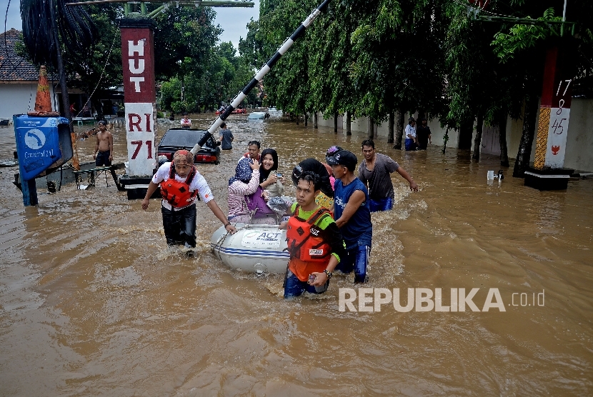 Warga dengan menggunkan perahu karet melintasi banjir akibat luapan Sungai Ciliwung, Bukit Duri, Jakarta, Kamis (16/2). 