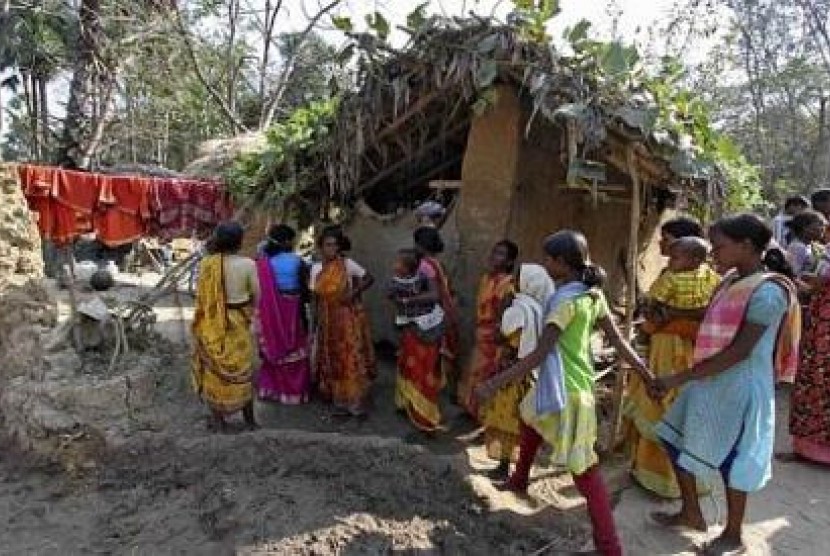 Warga desa berjalan di dekat gubuk lumpur tempat di mana korban diserang 13 lelaki dan diperkosa bergiliran atas perintah tetua desa.