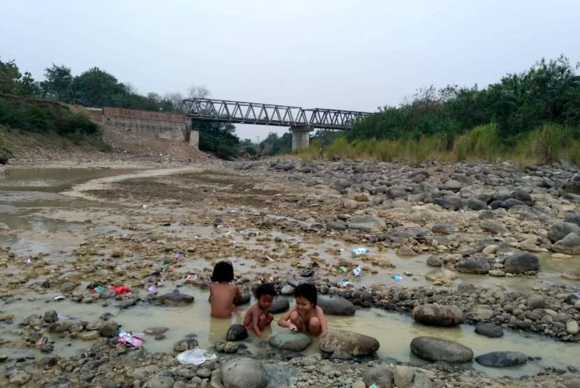 Warga Desa Cibarusah Kota sedang mandi di Kali Cipamingkis