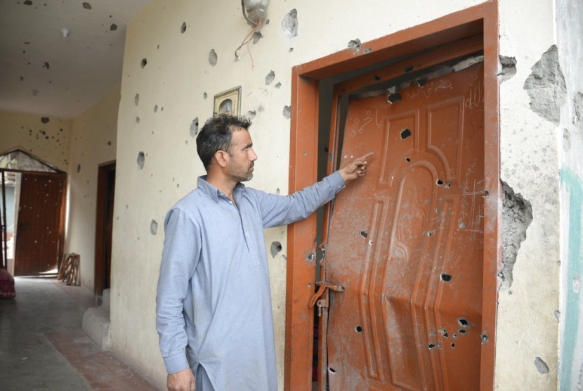 Warga desa Kashmir Pakistan menunjukkan pintu rumahnya yang hancur karena tembakan roket di sepanjang perbatasan Mandhol di Garis Kendali (LoC) antara Pakistan dan Kashmir India, Jumat (23/2).