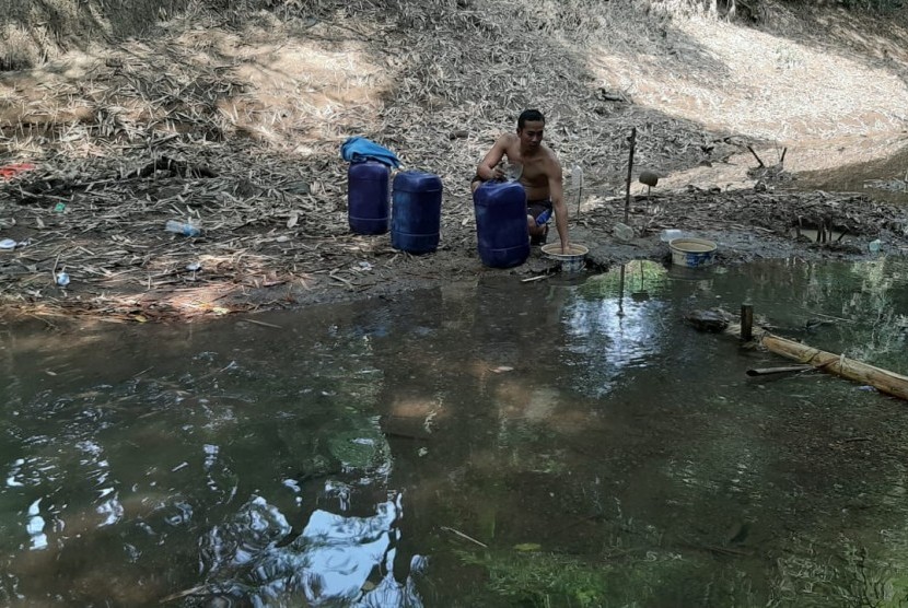 Warga Desa Ridogalih sedang mengambil air di Kali Cihoe yang mulai mengering pada Jumat (28/6). Desa Ridogalih merupakan satu dari tiga desa di Kecamatan Cibarusah, Kabupaten Bekasi, yang dilanda kekeringan sejak dua bulan terakhir. 