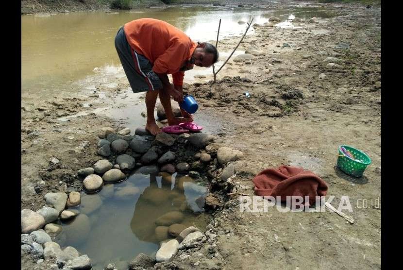 Warga Desa Sinar Jati Kec. Cibarusah Kab. Bekasi dilanda kekeringan dan mengambil air di kali Cipamingkis, Senin (6/8).